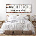 Give It to God and Go to Sleep sign above a white bed